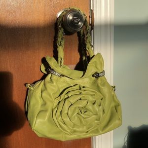 Green bag with flower detail on front.